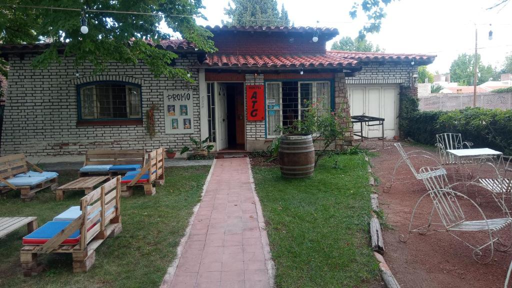 a brick building with benches and a building with writing on it at HOSTEL ATG in Ciudad Lujan de Cuyo
