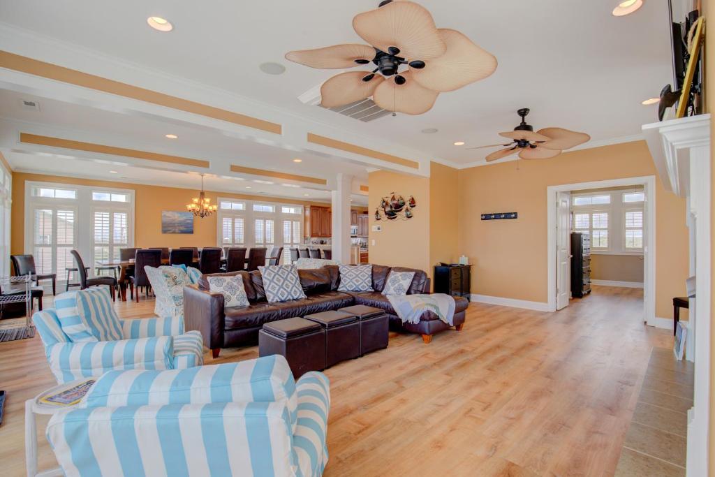 a living room with couches and a ceiling fan at The Lazy Beagle in North Topsail Beach