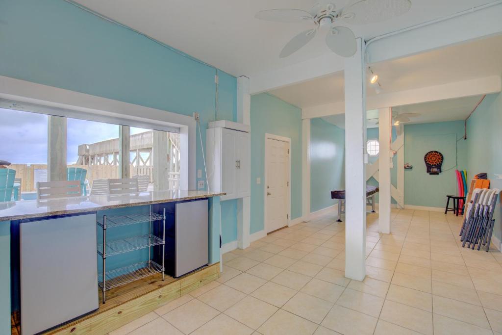 a large kitchen with blue walls and a large window at The Lazy Beagle in North Topsail Beach