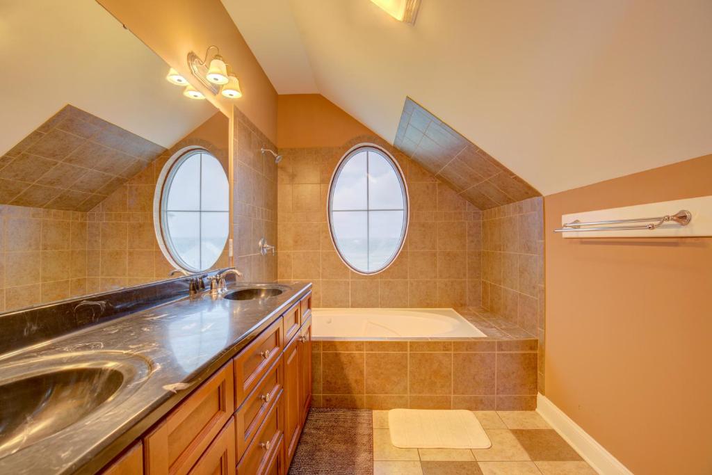 a bathroom with a sink and a tub and two windows at The Lazy Beagle in North Topsail Beach