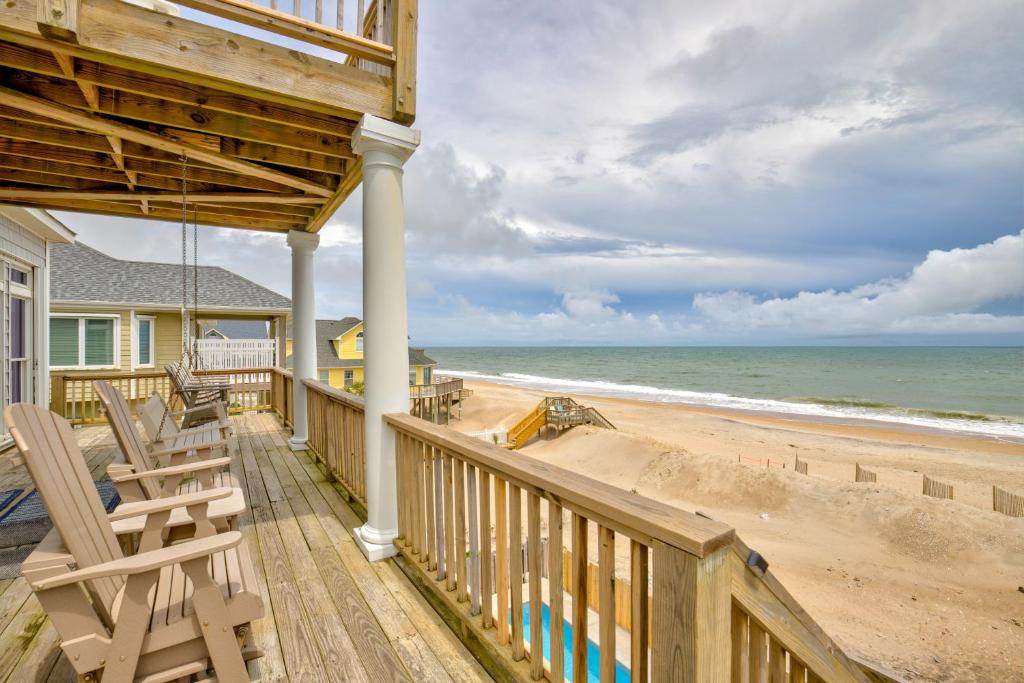a house with a deck with chairs and the beach at The Lazy Beagle in North Topsail Beach