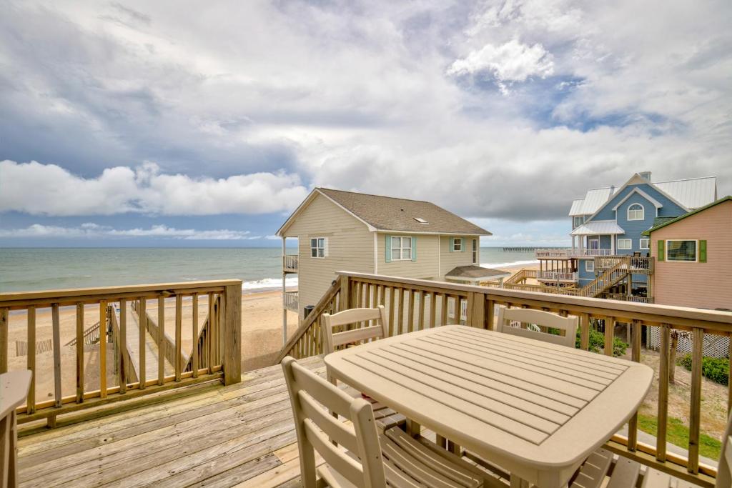 a wooden deck with a table and a view of the beach at The Lazy Beagle in North Topsail Beach