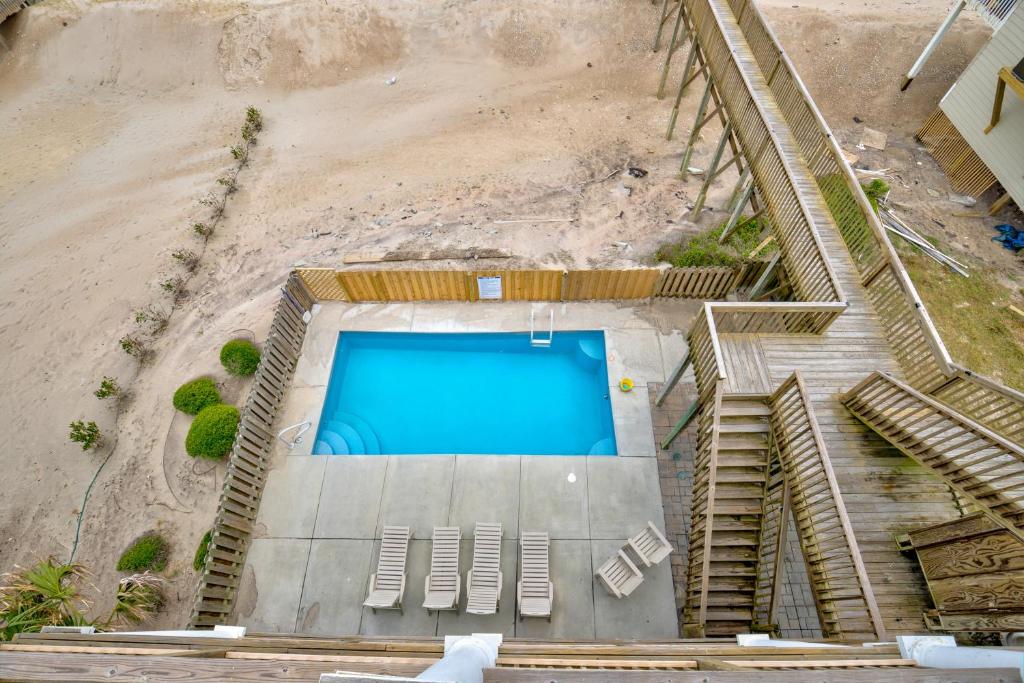 an overhead view of a swimming pool with chairs and stairs at The Lazy Beagle in North Topsail Beach