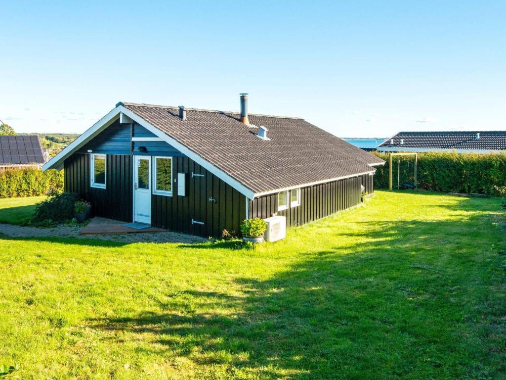 a small house in a field of green grass at 6 person holiday home in R nde in Rønde