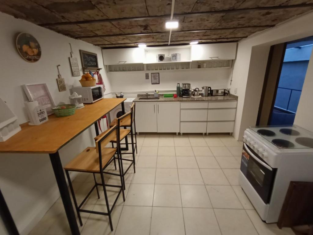 Il comprend une cuisine équipée d'une table, de chaises et d'une cuisinière. dans l'établissement Lounge BA, à Buenos Aires