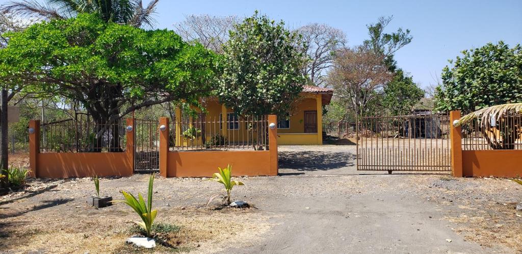 una recinzione di fronte a una casa gialla di cabañas playa guanico a Tonosí