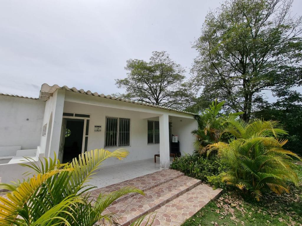 una pequeña casa blanca con entrada en VILLETA, CASA CAMPESTRE CERCA DE PAYANDE, en Villeta