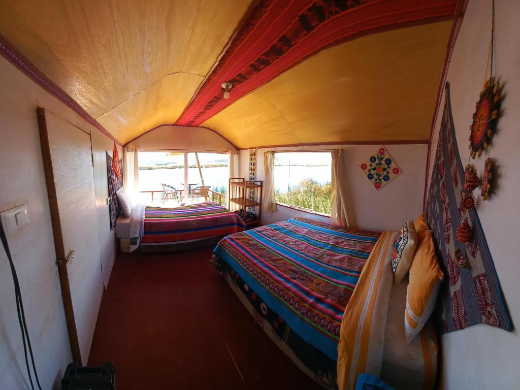 a small room with a bed and a table at Uros Titicaca Khantaniwa Lodge in Puno