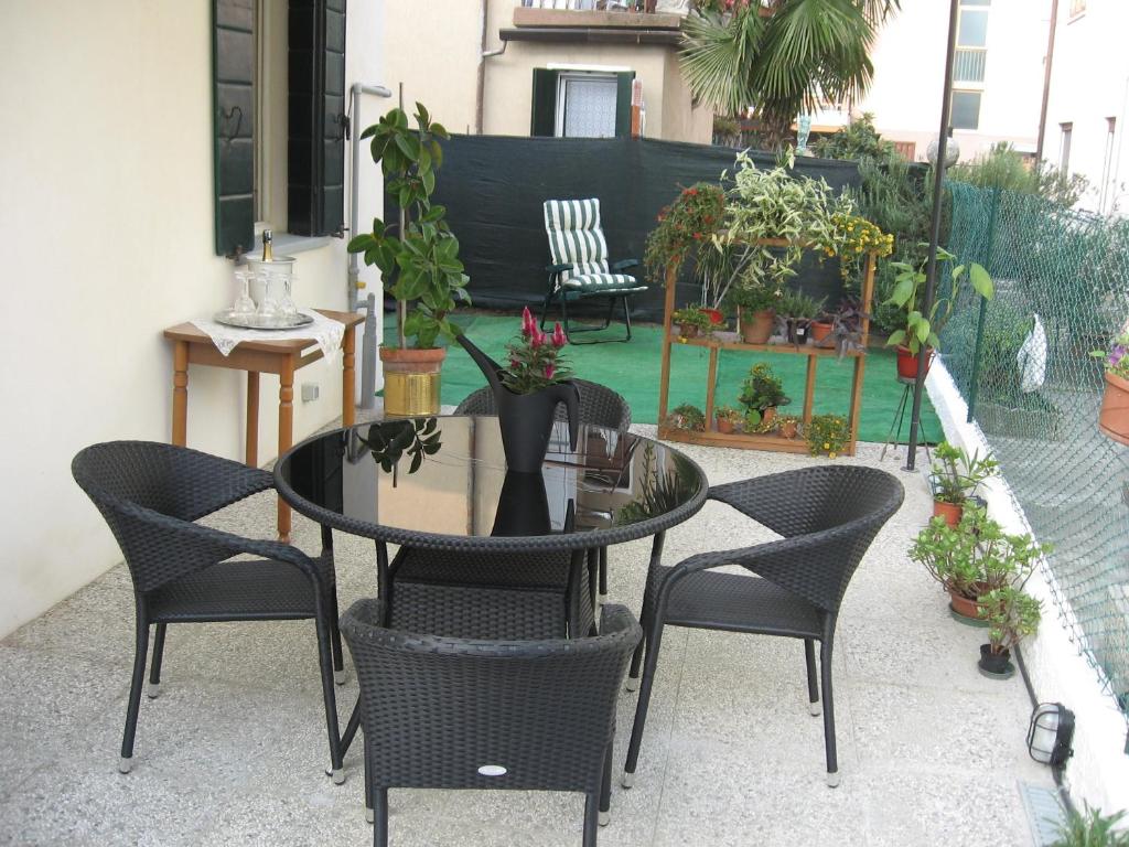 une table et des chaises sur une terrasse avec des plantes dans l'établissement Da Rina, à Mestre