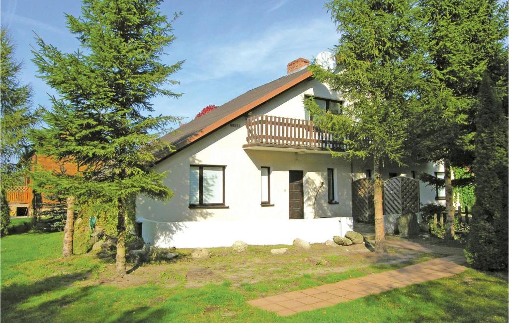 Cette maison blanche dispose d'un balcon dans la cour. dans l'établissement Nice Home In Choczewo With House A Panoramic View, à Lubiatowo