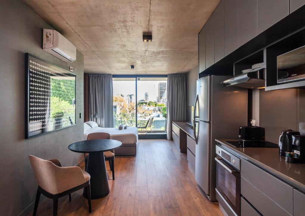eine Küche mit einem Tisch und ein Zimmer mit einem Sofa in der Unterkunft Live Soho Boutique & Apartments Palermo Soho in Buenos Aires
