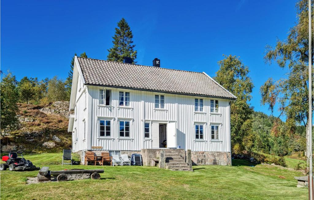 a white house on a grassy field with trees at Stunning Home In Bjelland With 3 Bedrooms in Bjelland