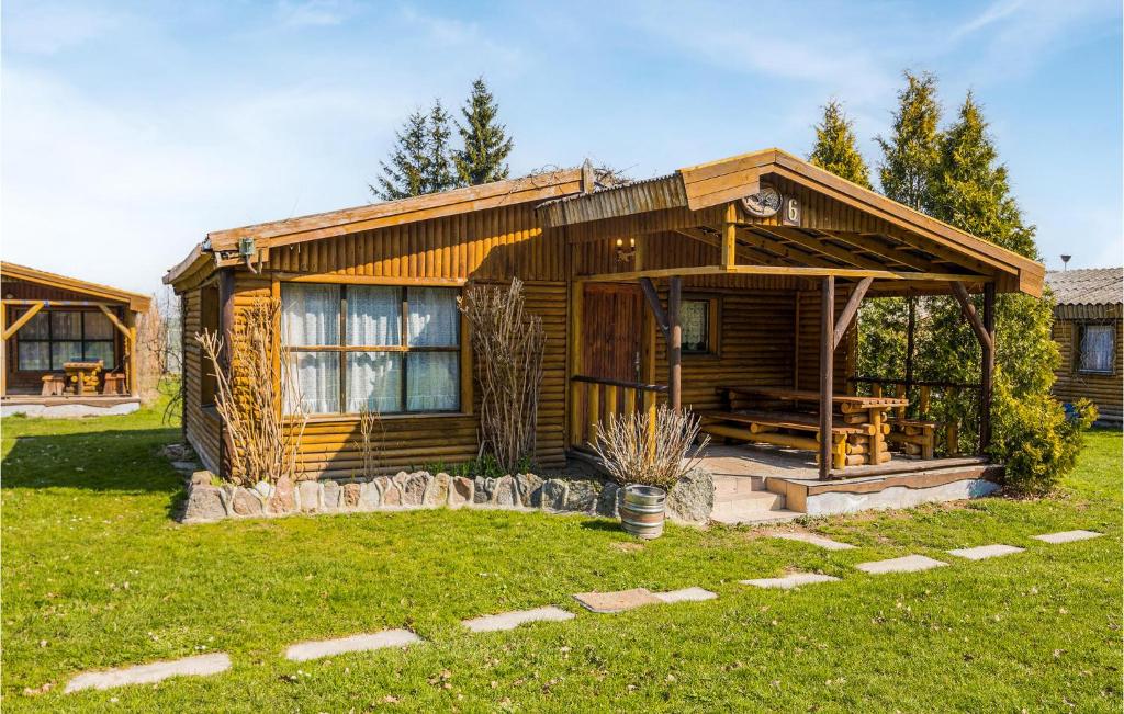 una cabina in legno con portico e prato di Amazing Home In Wilczeta With Kitchenette a WilczÄ™ta