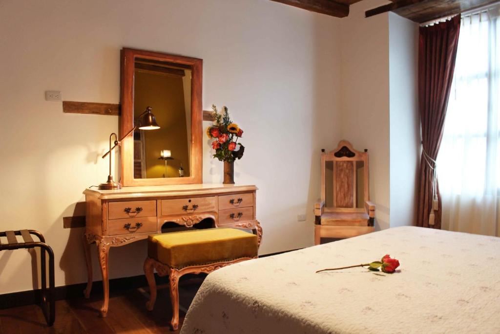 a bedroom with a bed and a dresser with a mirror at Old Town Quito Suites, Heritage Boutique Hotel, Where Every Detail Tells a Story in Quito