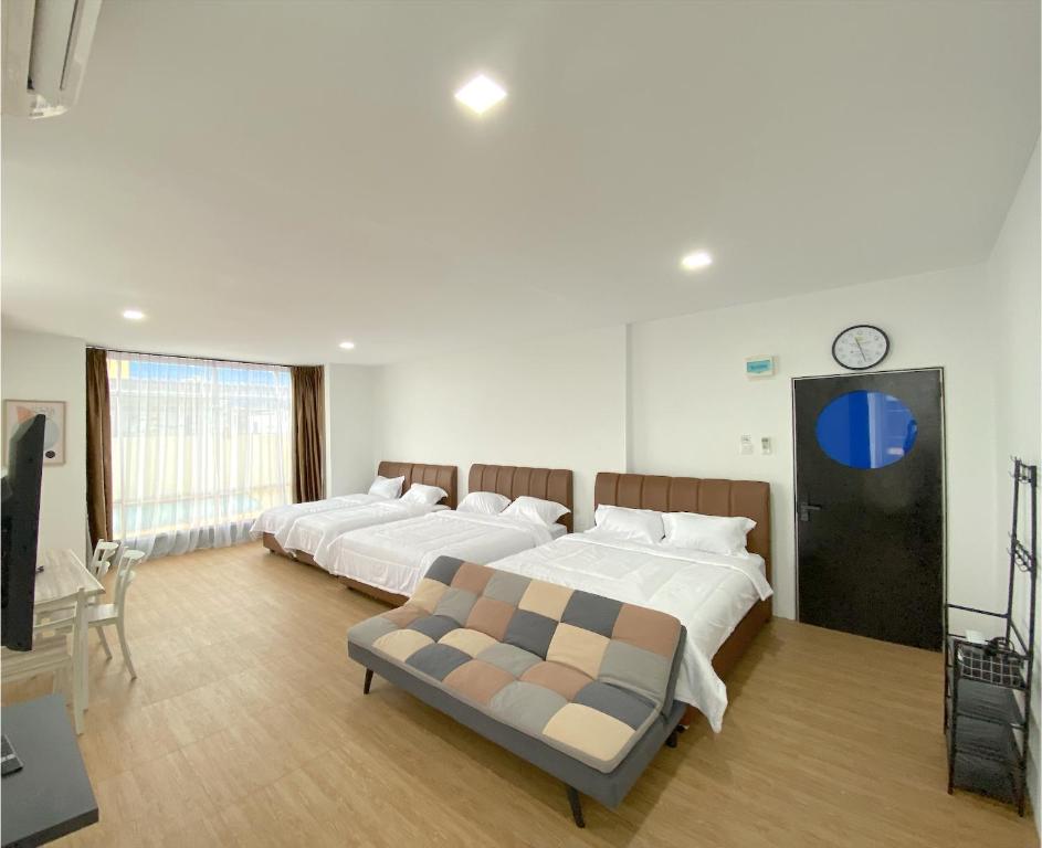 ナゴヤにあるCN Homestay B3 Floor 2 at Nagoya Hill Mallのベッドが2つあり、壁に時計がある寝室