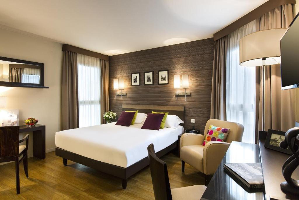 a hotel room with a bed and a chair at Citadines République Paris in Paris