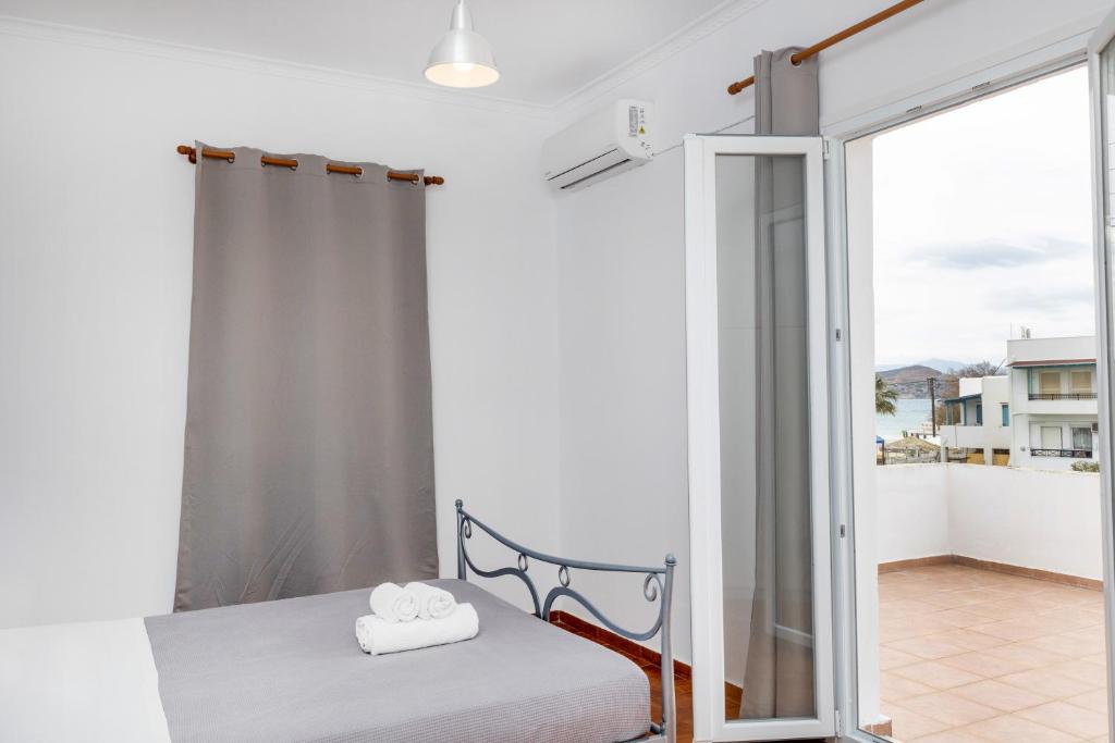 1 dormitorio con 1 cama y puerta corredera de cristal en Depis economy apartments, en Naxos Chora