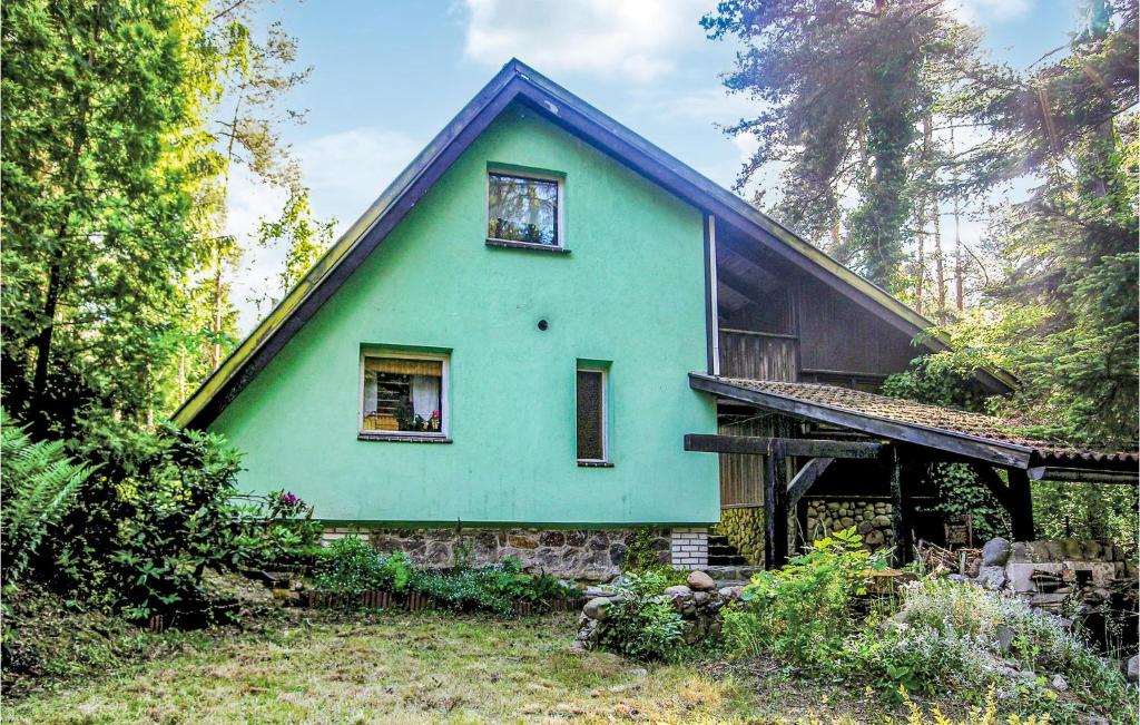 a green house with a blue roof at Holiday Home Kaminsko Uljalowcowa in Kamińsko