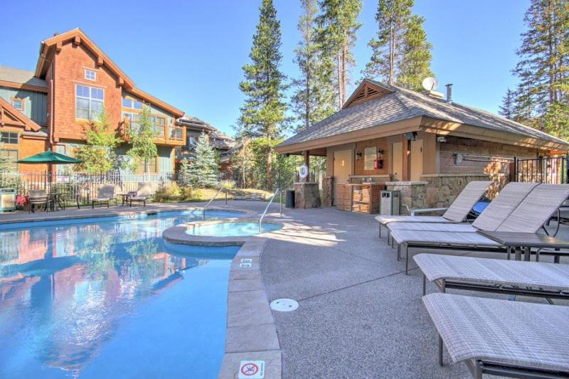 una casa con una piscina con sillas y una casa en Luxury 1 Bedroom Mountain Vacation Rental In Breckenridge With Access To A Hot Tub And Heated Garage Parking, en Breckenridge
