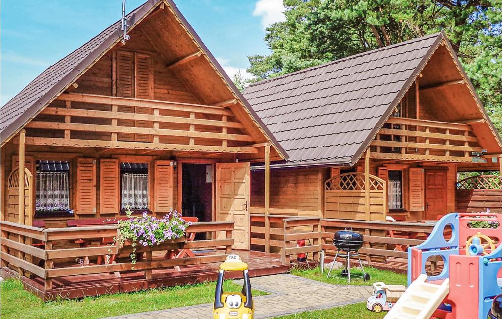 een houten huis met een speeltuin ervoor bij Nice Home In Jaroslawiec With 2 Bedrooms And Wifi in Jarosławiec