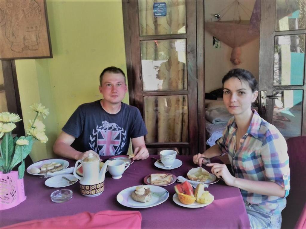 Um homem e uma mulher sentados à mesa com comida. em Ella Tunnel Corner Inn em Ella