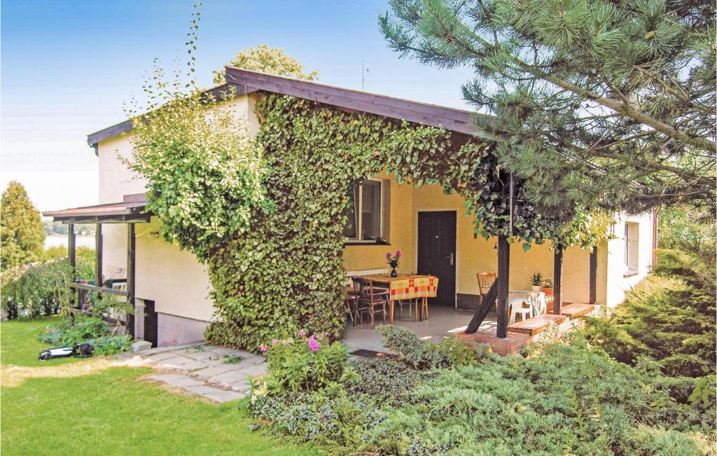 a yellow house with a table and chairs in a yard at Holiday Home Moscienica Moscienicka Ii in Kórnik