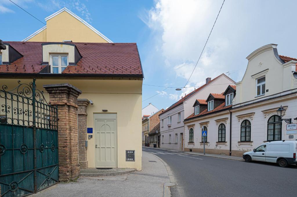 a street with houses and a gate in a town at Paon Boutique Apartments in Zagreb