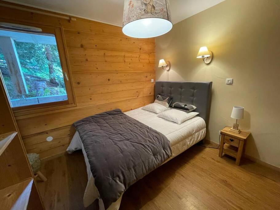 a bedroom with a large bed in a wooden wall at Appartement 4 chambres avec grande terrasse in Les Deux Alpes