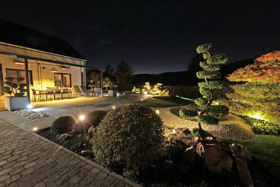 - un jardin avec des lumières la nuit et un bâtiment dans l'établissement ONSEN PLACE by Ardenne Places, à Spa