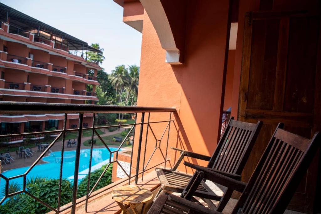 a balcony with two chairs and a swimming pool at Ronne's 2Bhk vacation rental near Baga Beach in Calangute