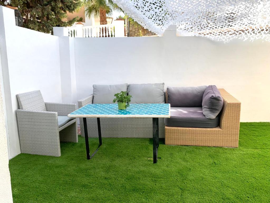 a couch and a table in a room with grass at Apartamento Cerro del Aguila in Mijas