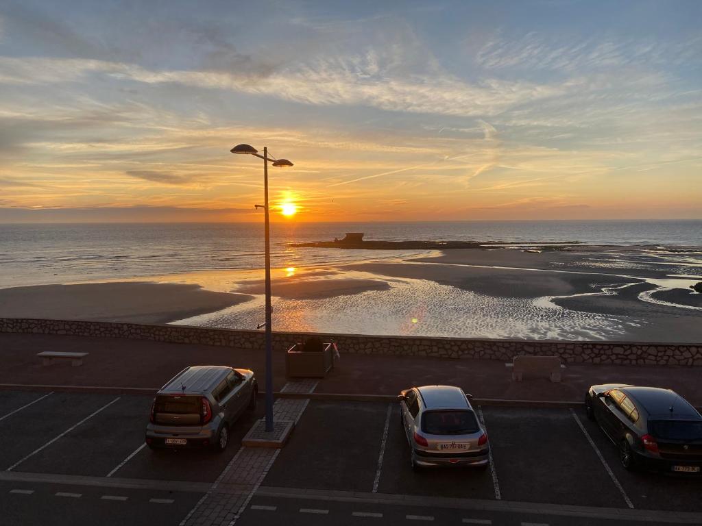 een groep auto's geparkeerd op een parkeerplaats bij de oceaan bij L'HORIZON in Le Portel