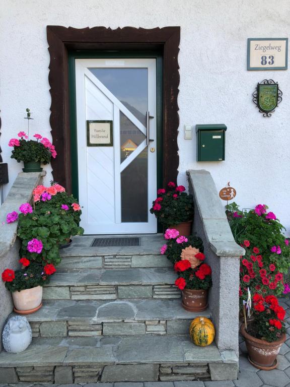 une porte avec des fleurs et des plantes en pot sur les escaliers dans l'établissement Ferienwohnung Susanne Hillbrand, à Bad Aussee