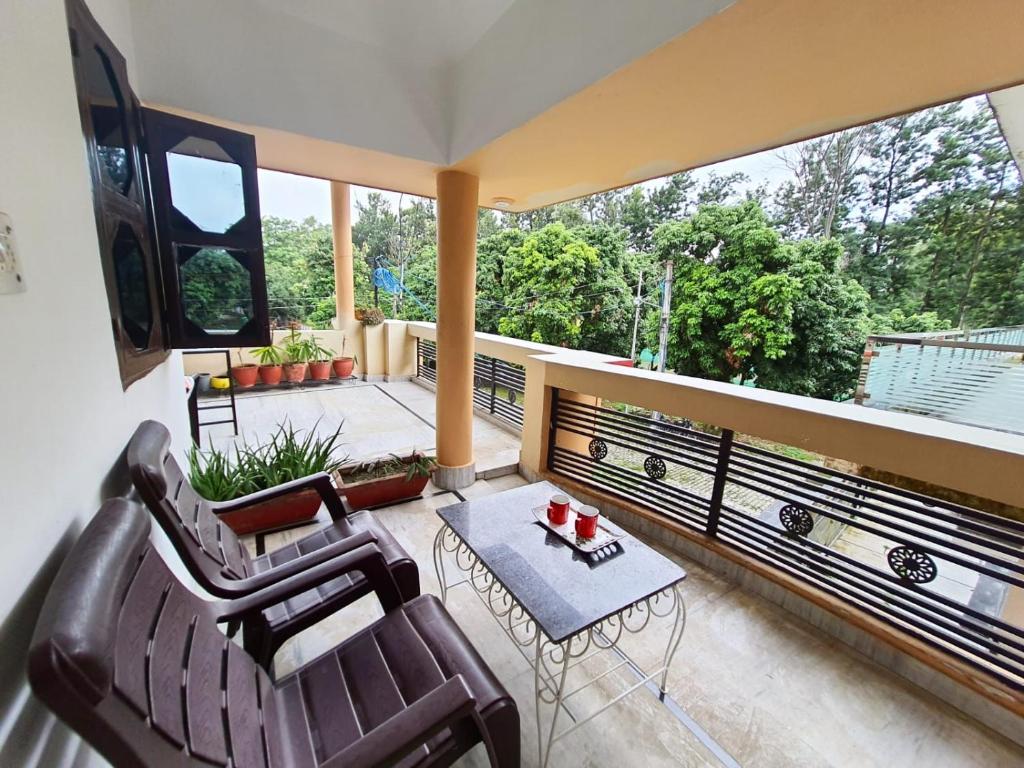 a balcony with two chairs and a table on a balcony at Nature View Homestay in Dehradun