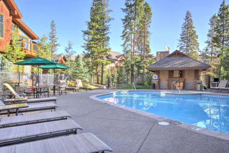 Una piscina con tumbonas y una casa. en Luxury 2 Bedroom Mountain Vacation Rental In Breckenridge With Access To A Hot Tub And Heated Garage Parking, en Breckenridge