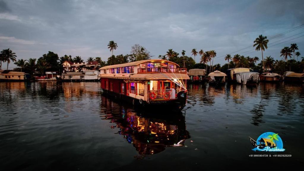 a boat in the water with its lights on at Vaishnav Tours in Alleppey