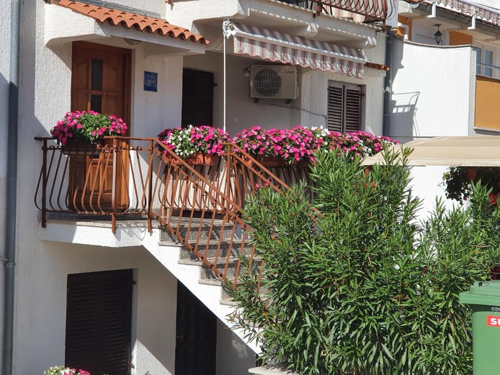 un edificio con 2 balcones con flores. en Apartments Antolović, en Vrsar
