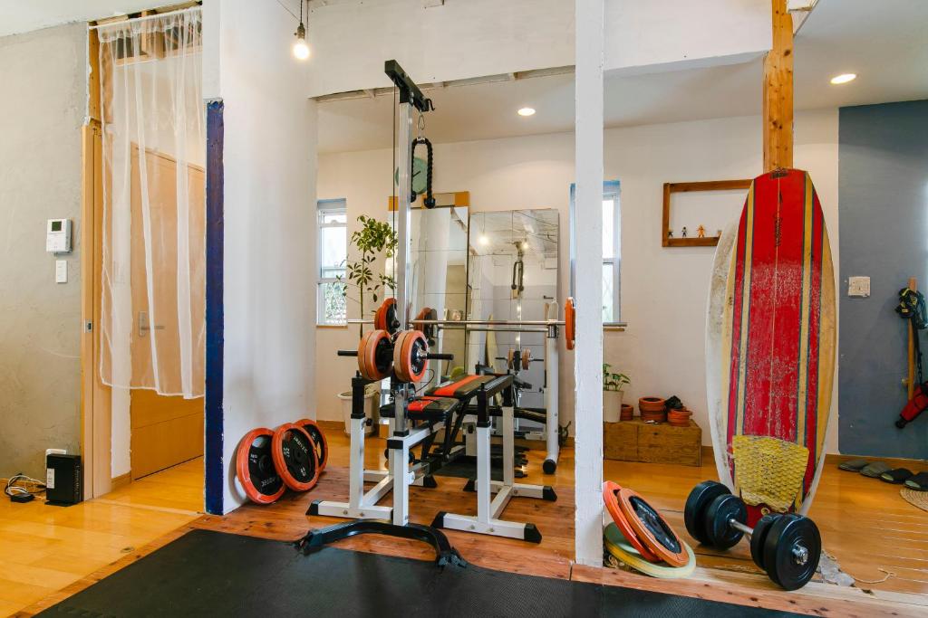 une salle de sport avec une planche de surf et des poids dans l'établissement jiro de kamakura, à Kamakura