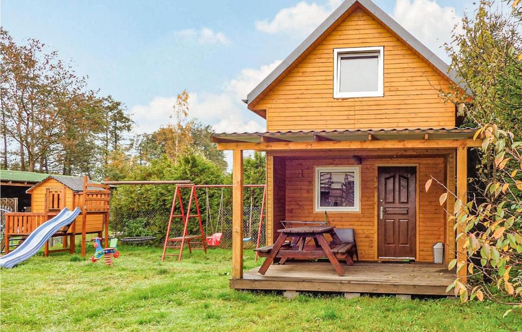 ein kleines Haus mit einem Picknicktisch und einem Spielplatz in der Unterkunft 2 Bedroom Pet Friendly Home In Karwienskie Blota in Karwieńskie Błoto Pierwsze