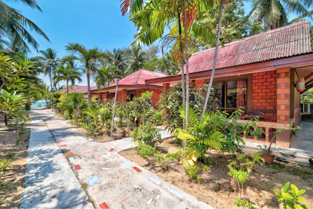 uma casa com palmeiras em frente em Sawai Home Resort em Nathon
