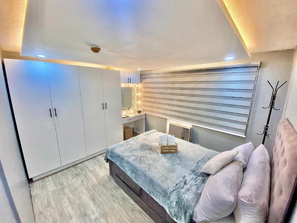 een slaapkamer met een bed en een groot raam bij IV’s Condo w/ Netflix, Wifi & Karaoke in Cainta