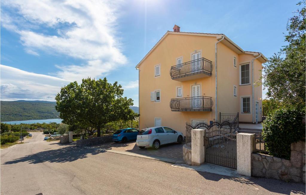 a large yellow building with cars parked in front of it at 2 Bedroom Nice Apartment In Kornic in Kornić