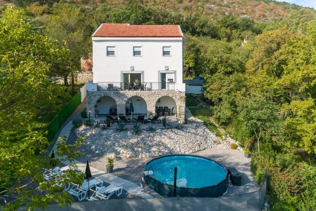 een luchtzicht op een huis en een zwembad bij Holiday house DINO in Bribir