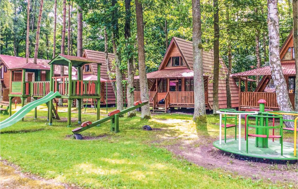 a group of playground equipment in front of a cabin at 2 Bedroom Amazing Home In Lukecin in Łukęcin