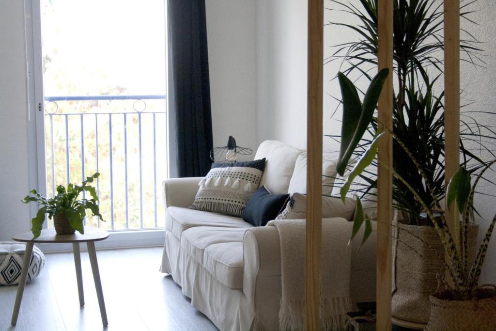 uma sala de estar com um sofá branco e uma varanda em Perigueux T2 proche du quartier historique em Périgueux