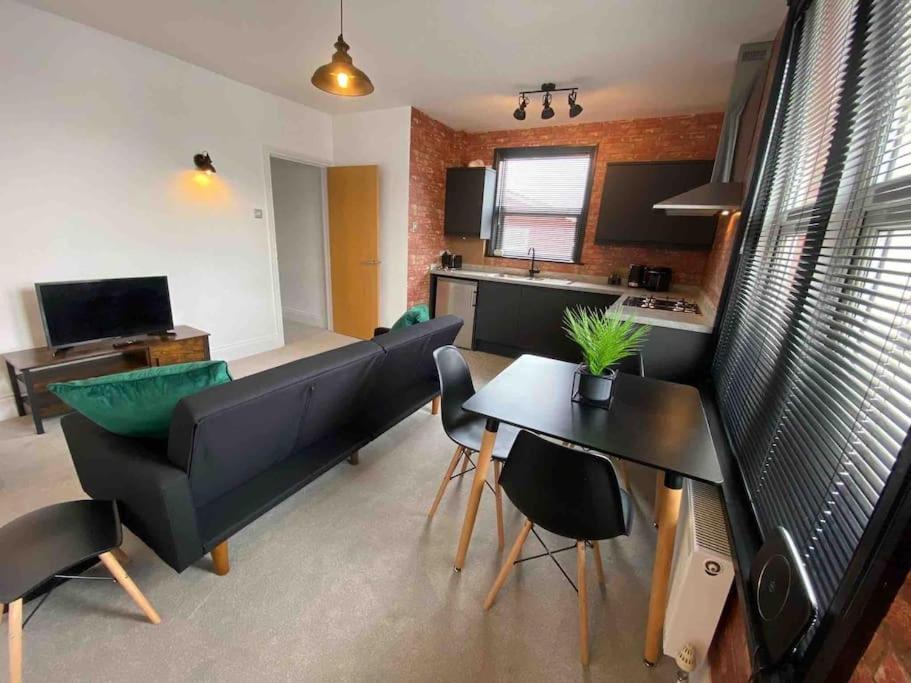 ein Wohnzimmer mit einem Sofa und einem Tisch in der Unterkunft 1 bed flat with parking near town centre in Emsworth