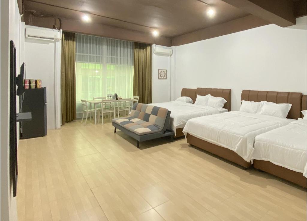 a bedroom with two beds and a chair and a table at CN Homestay C1 Floor 3 at Nagoya Hill Mall in Nagoya