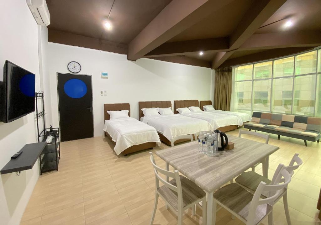 a room with two beds and a table and a tv at CN Homestay C2 Floor 3 at Nagoya Hill Mall in Nagoya