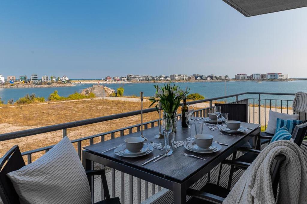 a table on a balcony with a view of the water at Ocean Star- 1 OG, Balkon, Hafenblick, Kamin in Olpenitz