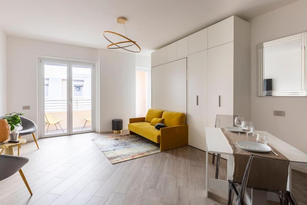 ein Wohnzimmer mit einem gelben Sofa und einer Küche in der Unterkunft Casa Parboni in Rom